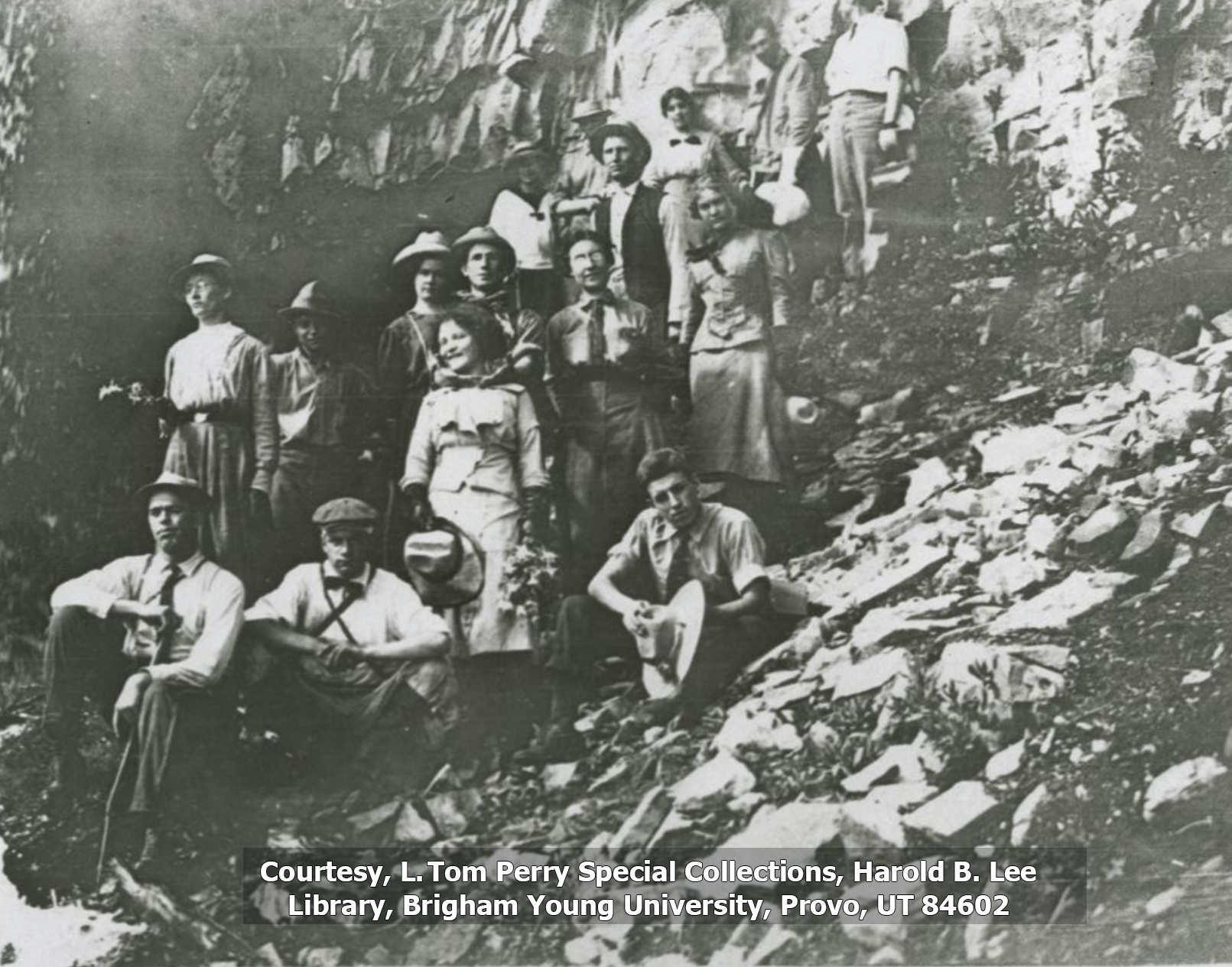 Group of students from the first summit hike stand by a waterfall in this black and white photo.